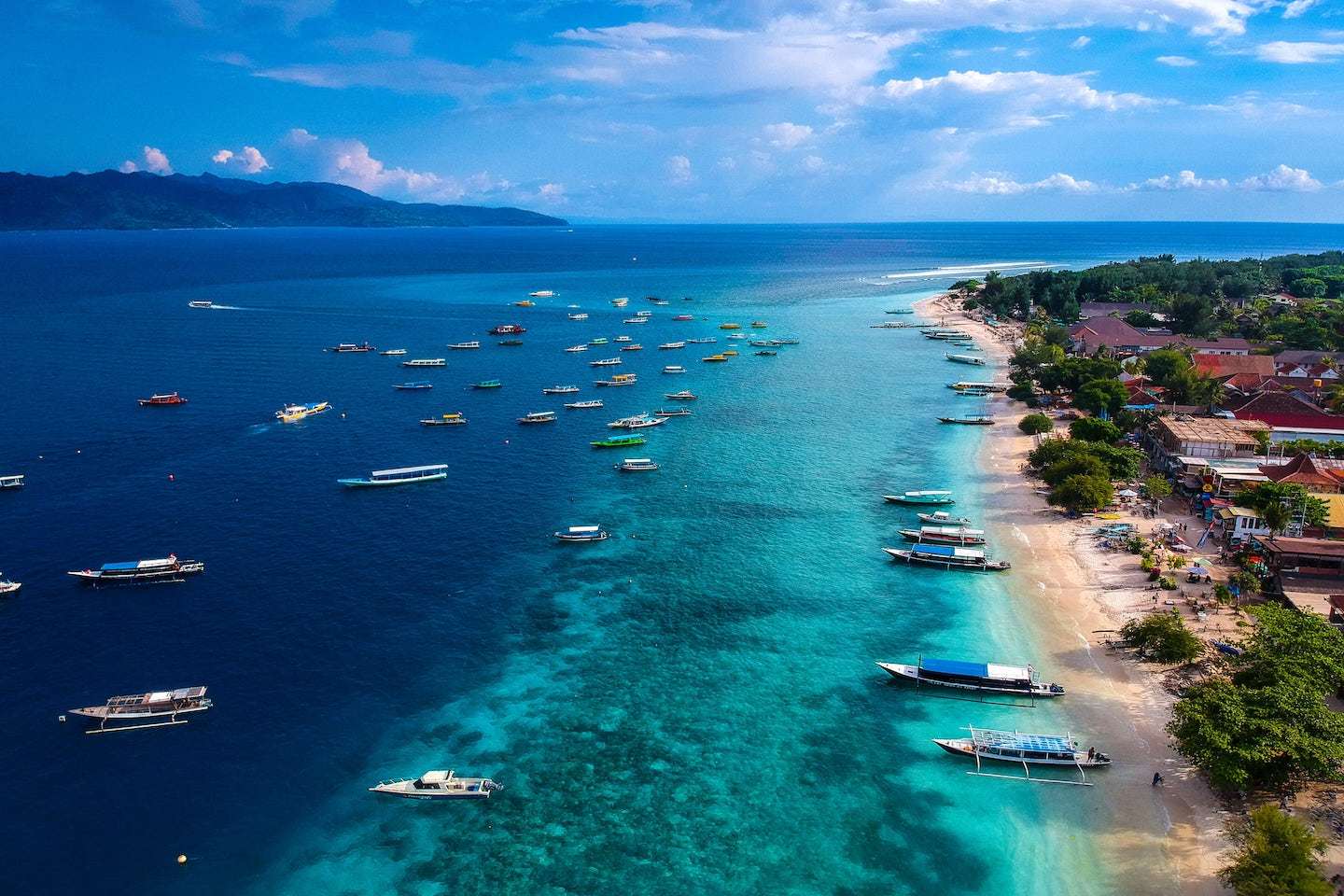shore of the gili islands surrounded by boats