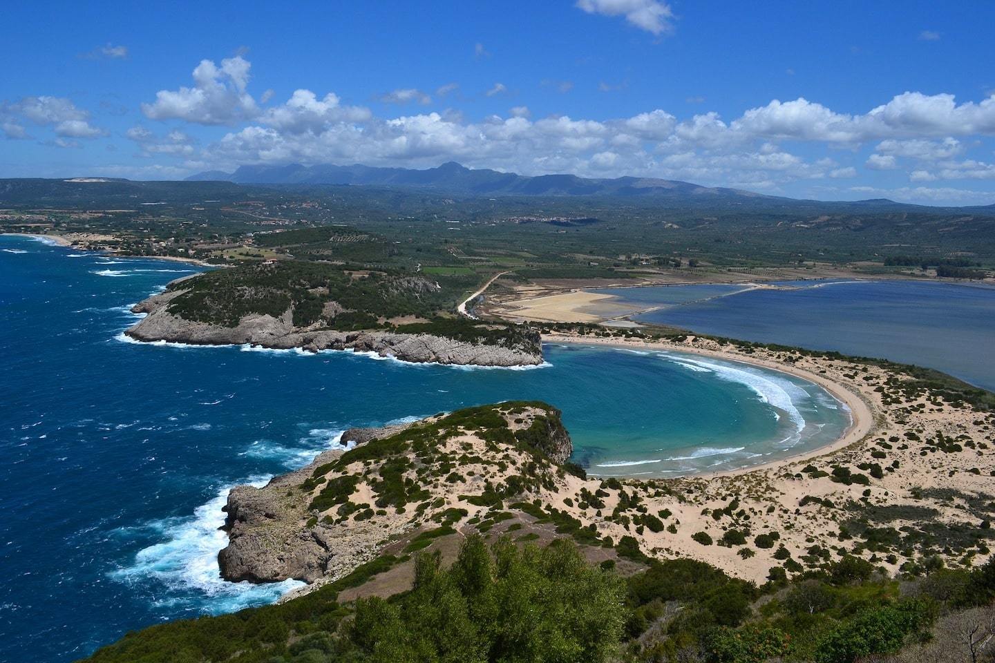 Aerial view of Voidokilia Beach in Greece with it's curved sand surrounded by mountains