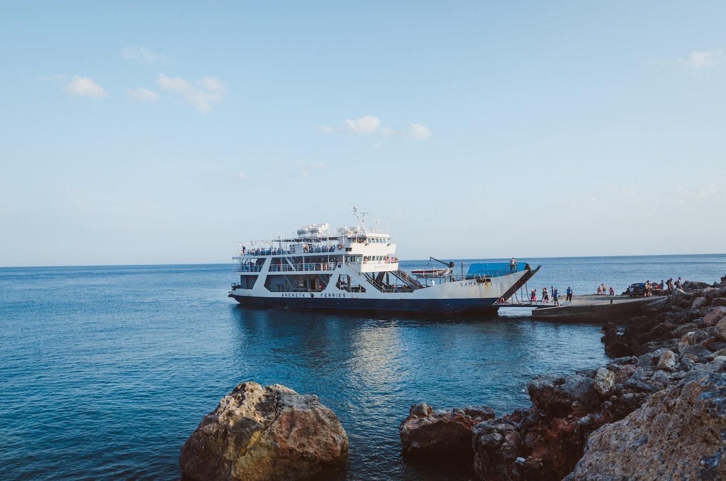 ferry dropping off passengers at pier in greece