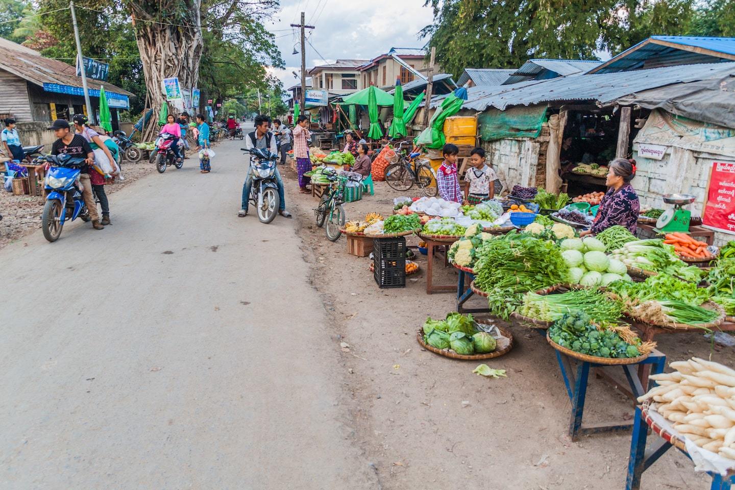 People selling vegetables on the side of the road at a market in Hsipaw Myanmar