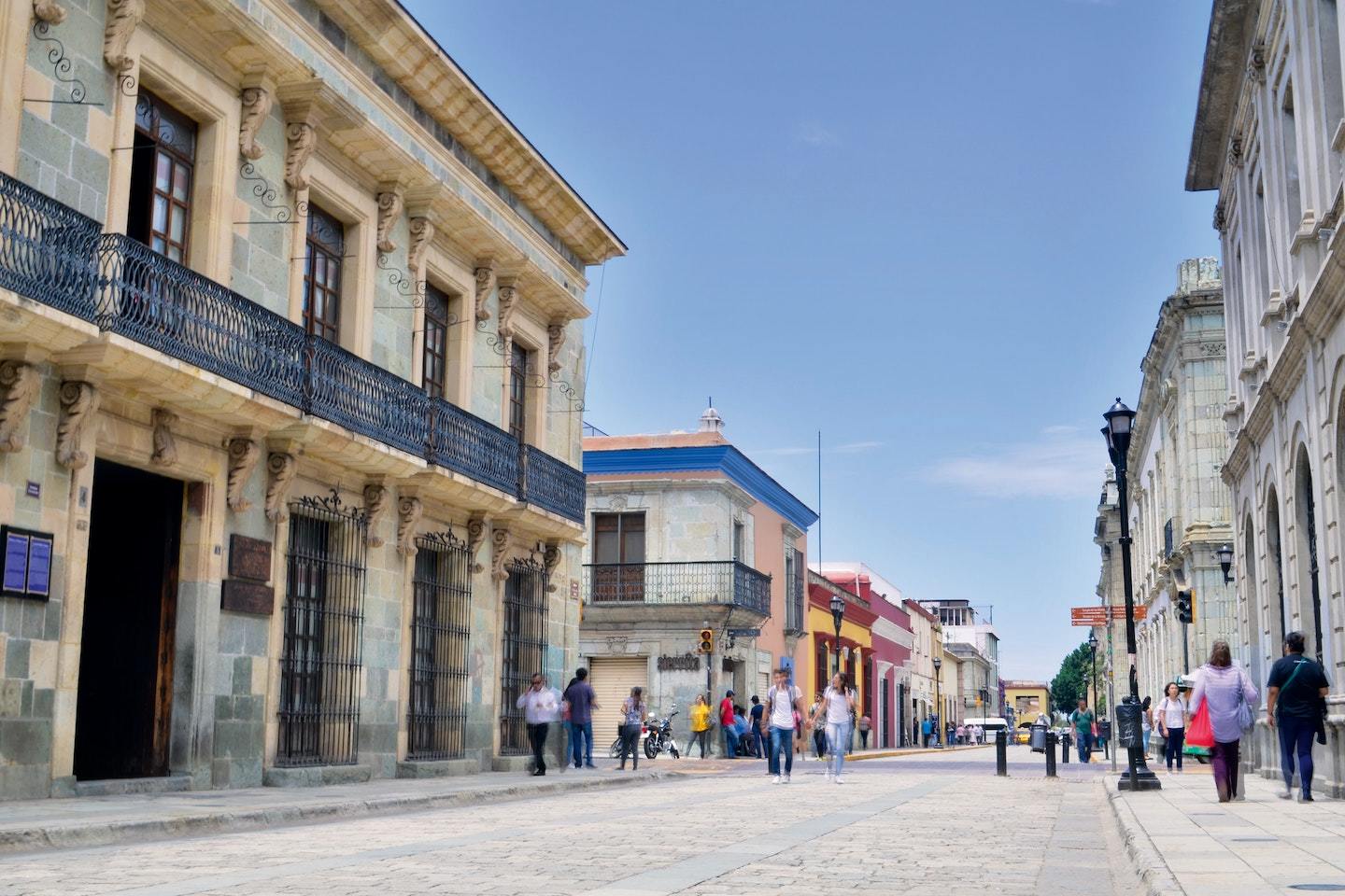 large street in oaxaca town center surrounded by buildings