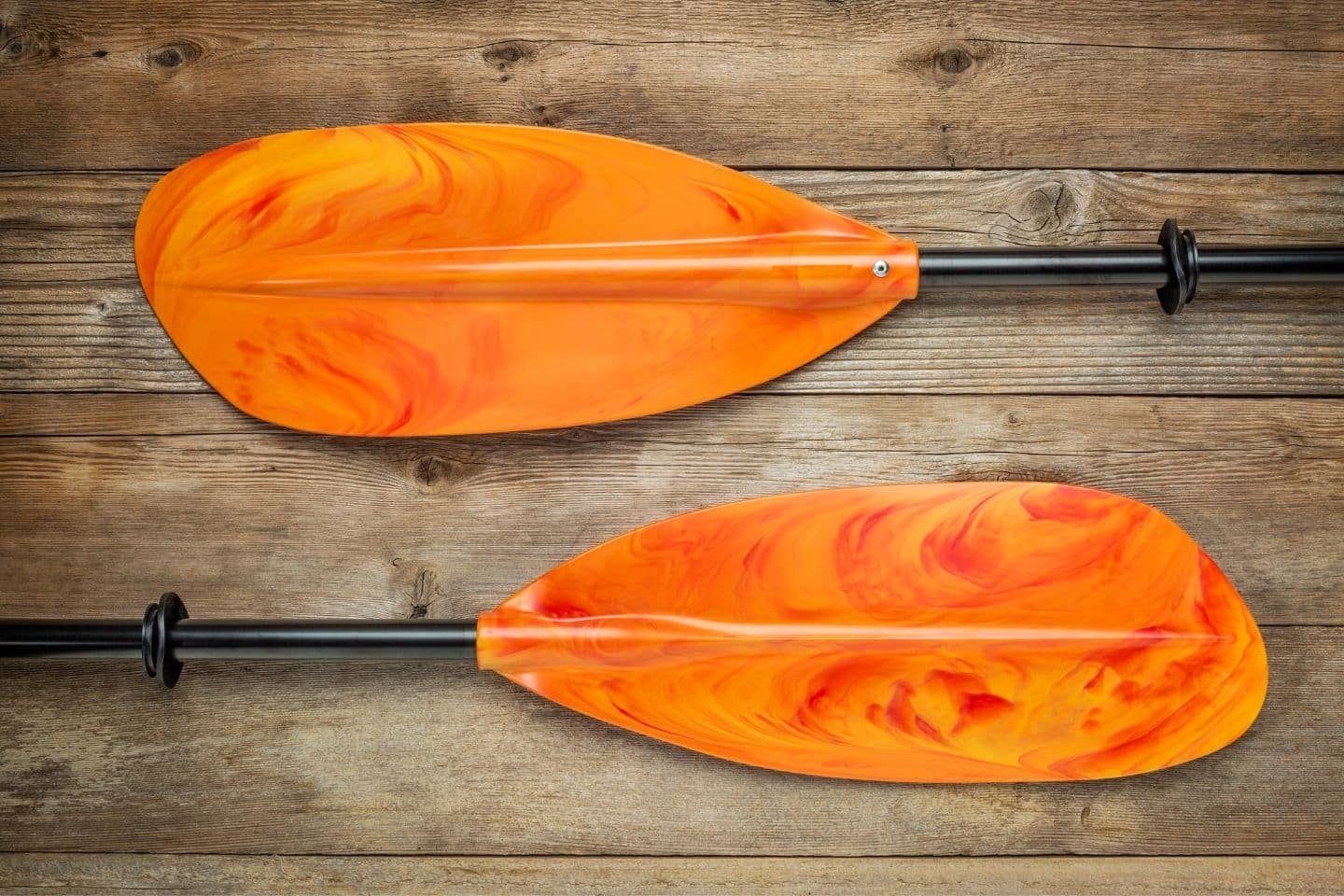 A pair of orange kayak paddle