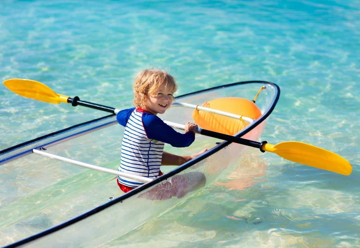 a little kid on a transparent kayak