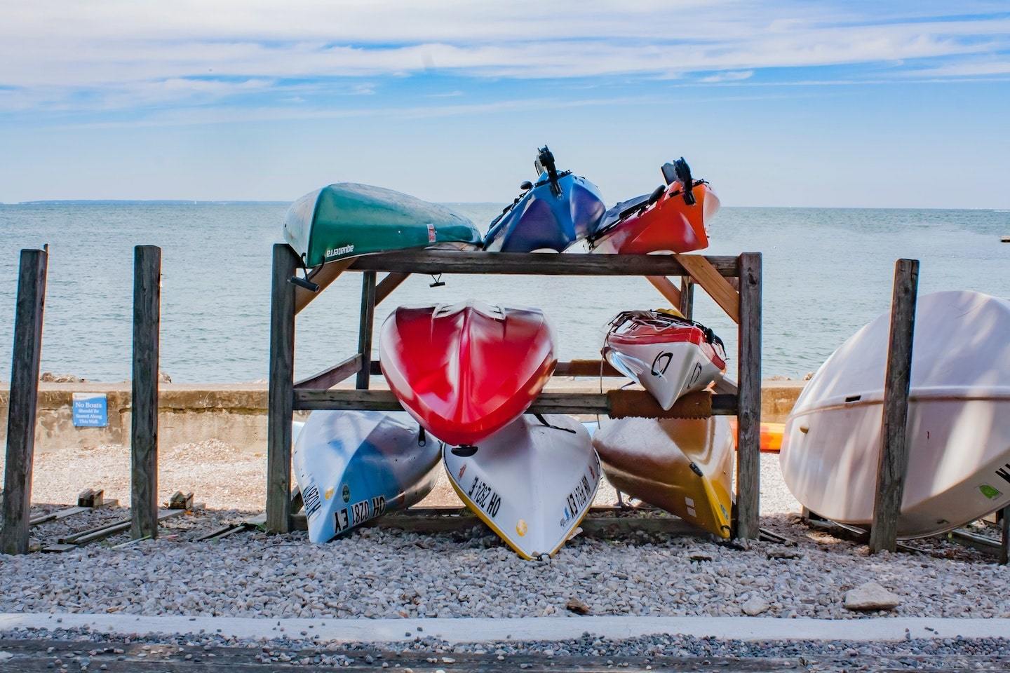 a rack on the beach showcasing the best sea kayaks