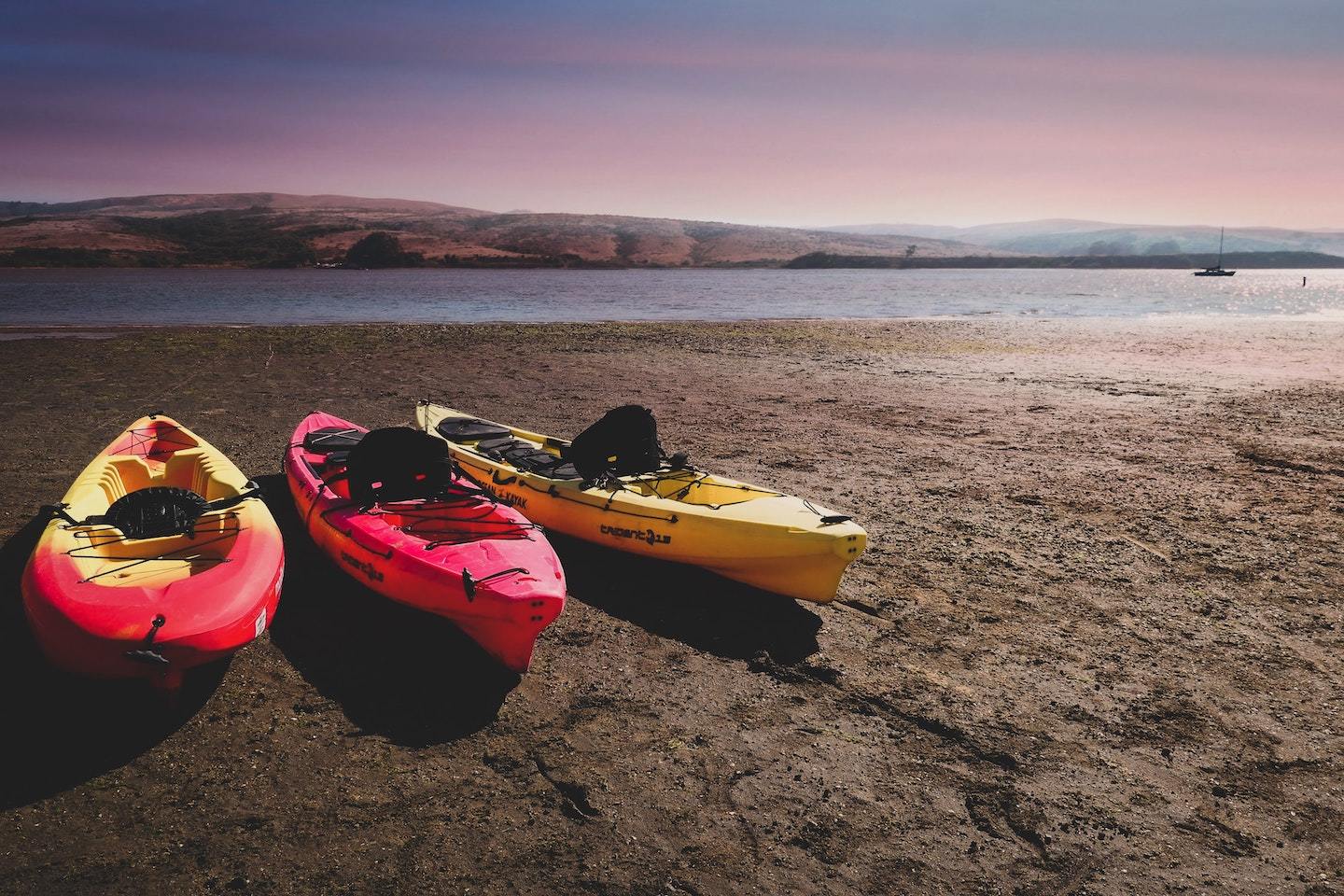 three kayaks showing their seats at sunset