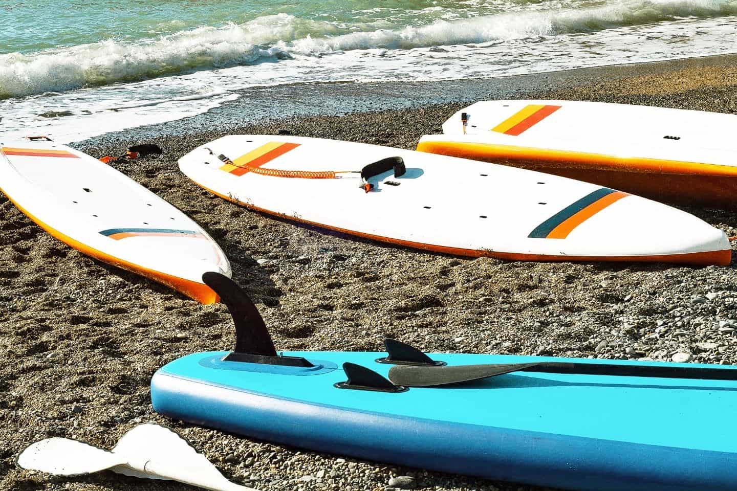 Pile of SUP paddle surfing on a shore