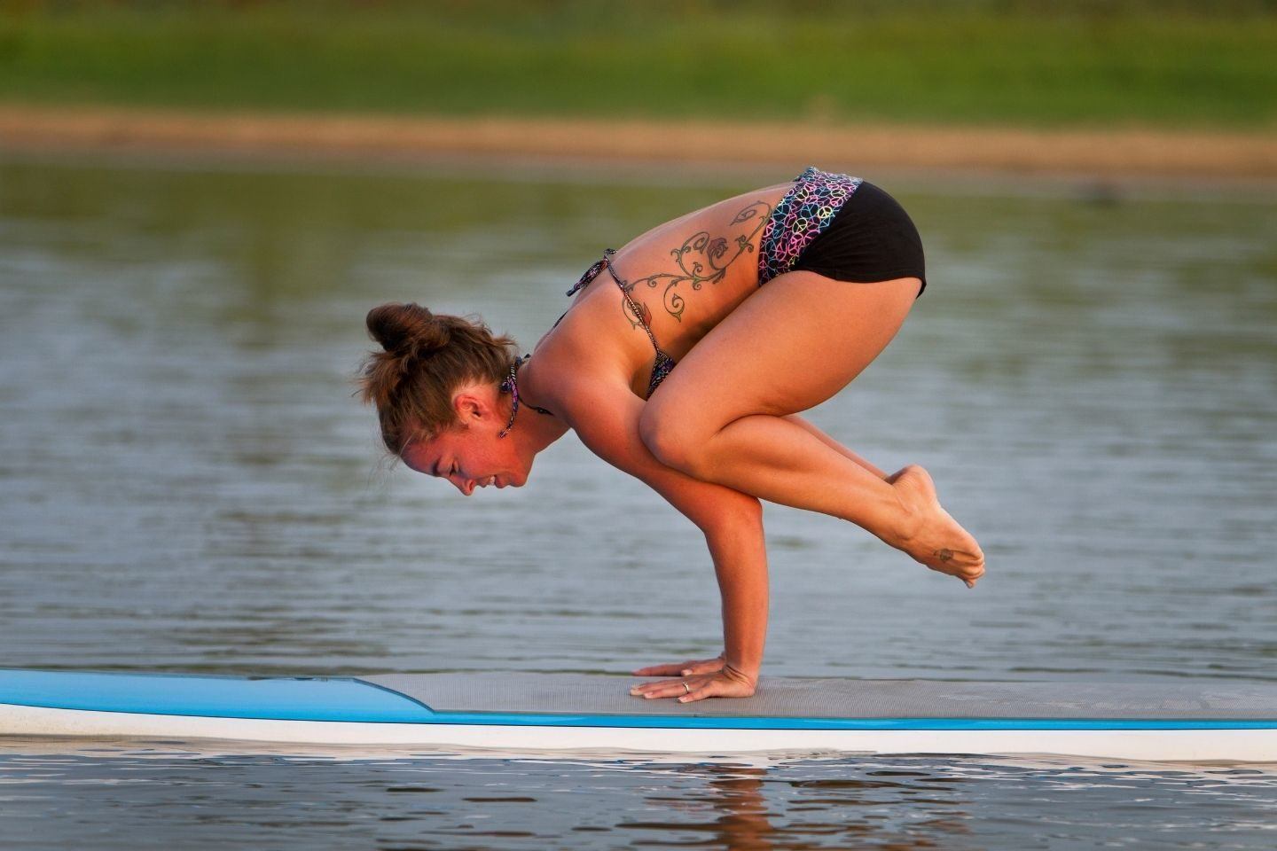 A woman practicing yoga on a paddle board