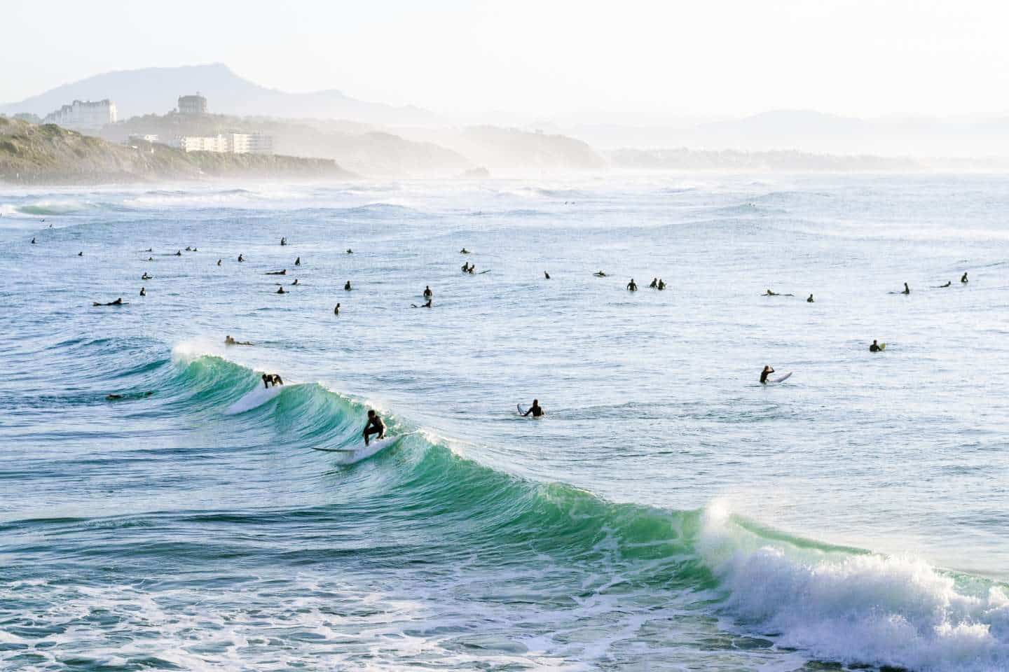 Surfers enjoying the waves in Biarritz, France (Best Surf Camps in France)