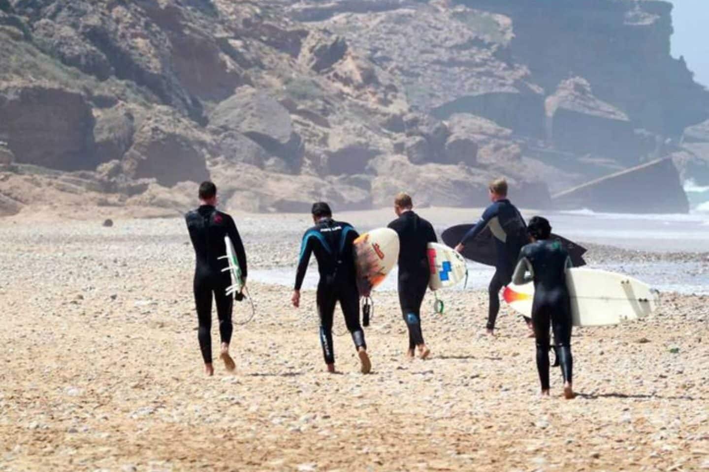 Group of surfers walking on the sand