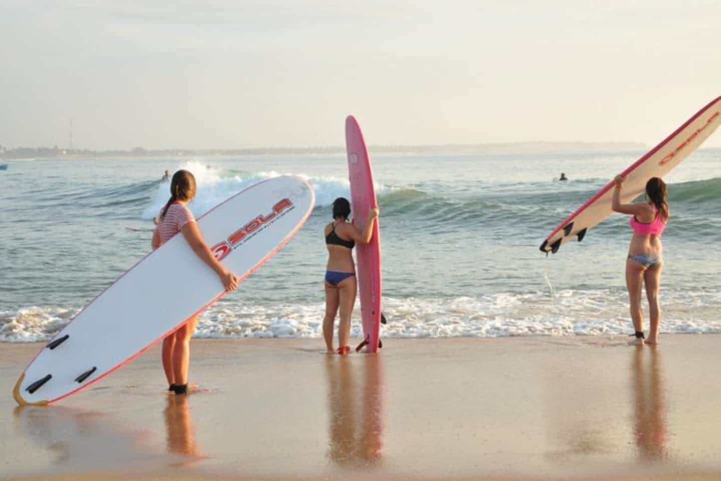 Three people getting ready to go surfing with Arugam Bay Surf Tours