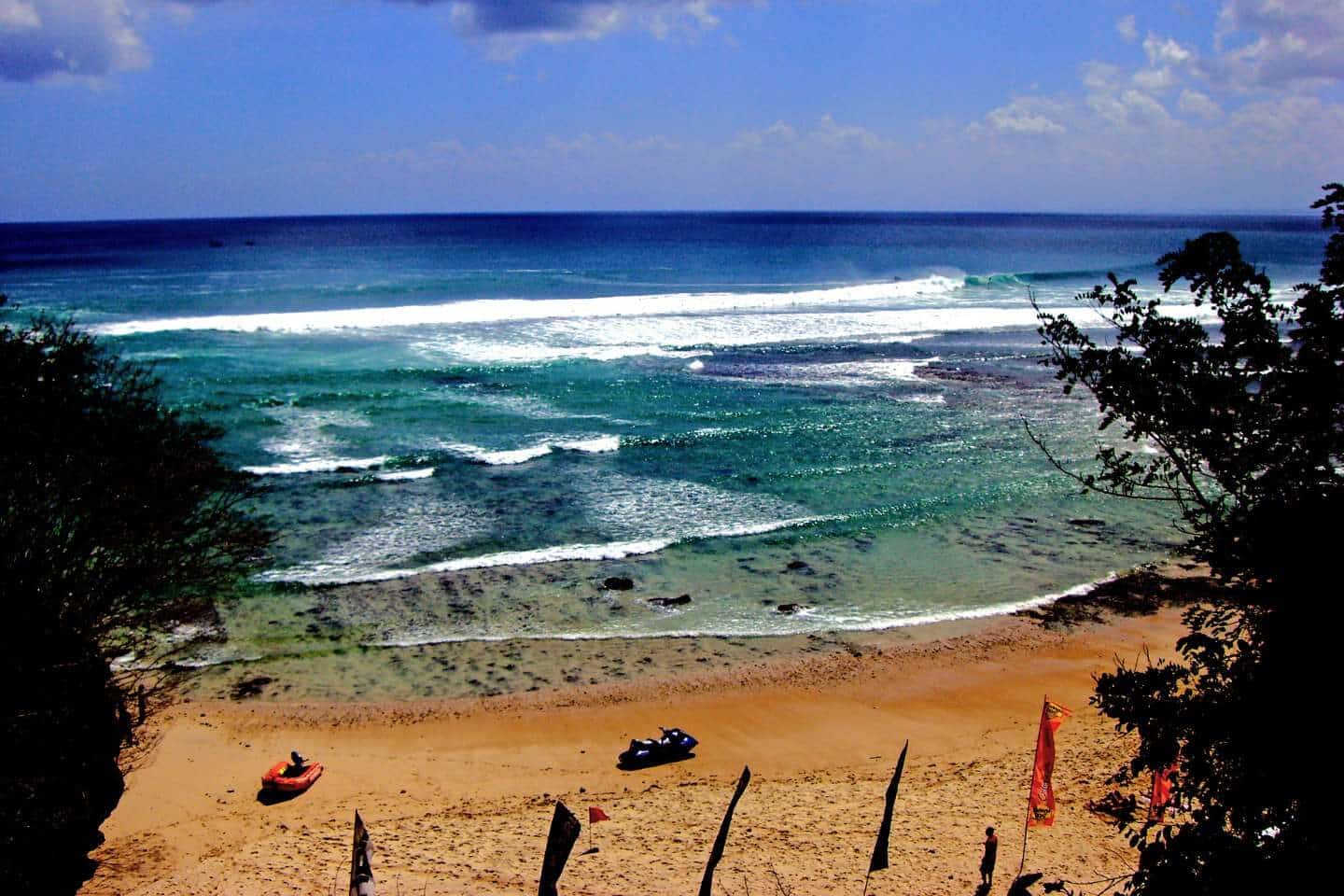 A beach in Uluwatu with blue skies and beautiful waves that are perfect for surfing