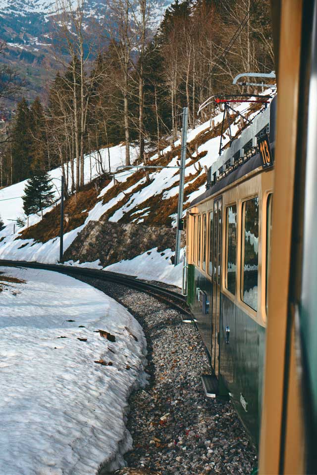 a train riding through the snowy scenes of switzerland